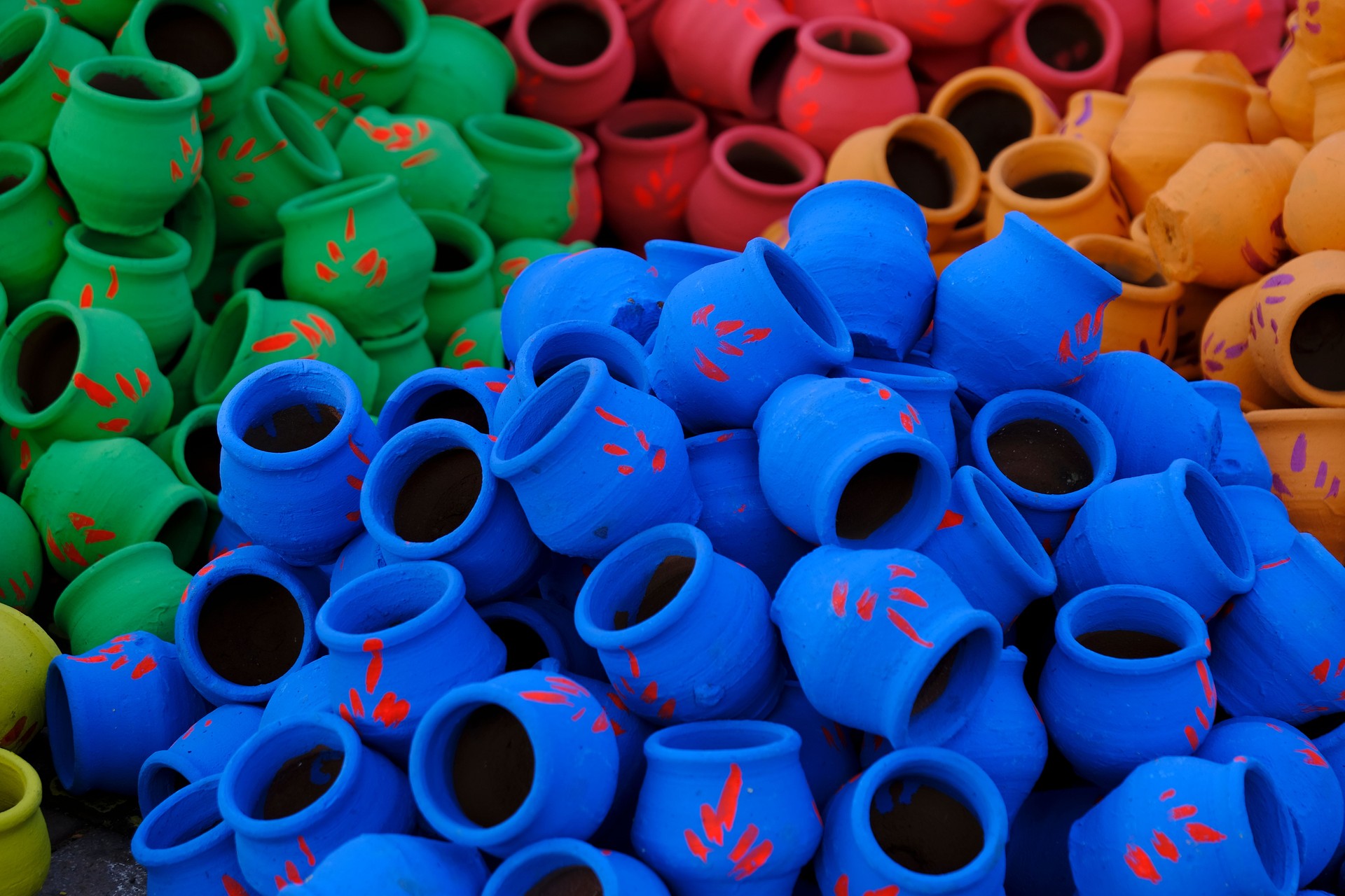A potter prepares earthen colorful pots ahead of Hindu festival Laxmi poojan (Diwali), Clay Colourful Pots for festival celebration.